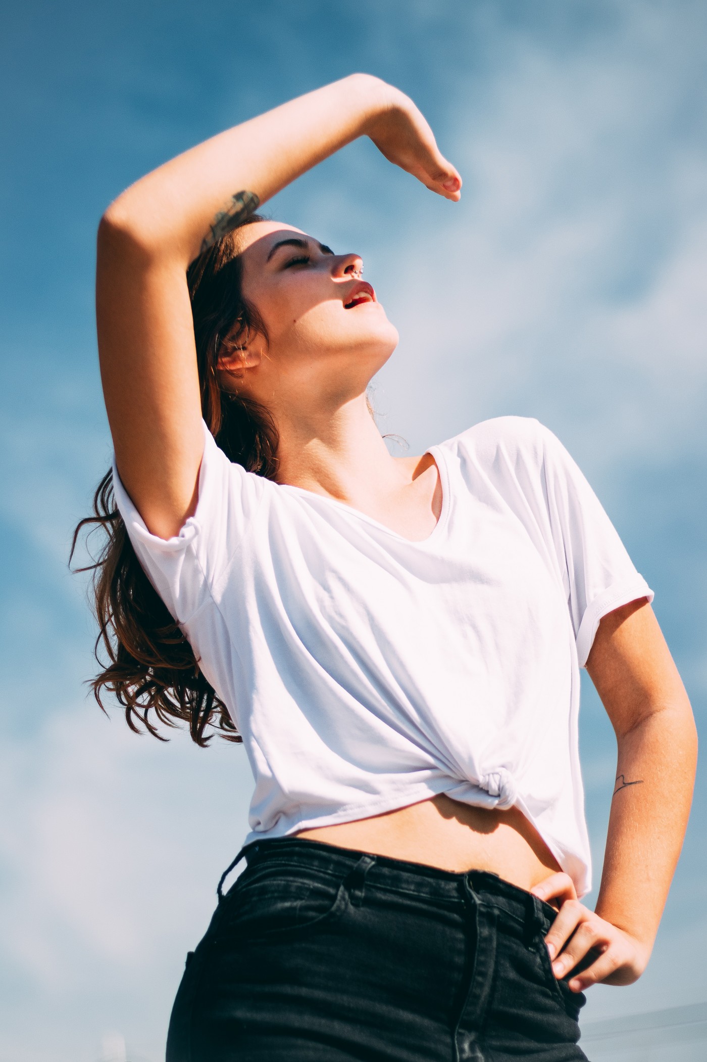 撑腰单手遮阳光摆造型的女子图片