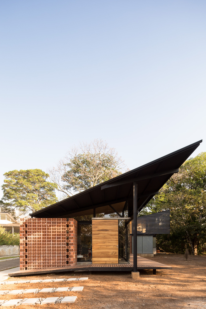 因私宅西侧面朝树林,建筑师将屋顶进行了抬升,让树梢的景色可以被住户看到。但必要的时候,芦苇制成的大门可以作为一道有机屏障,阻止那些穿过树隙的阳光进入室内。而当这些大门被完全打开时,私宅便与室外的小平台,庭院以及山沟融为一体。