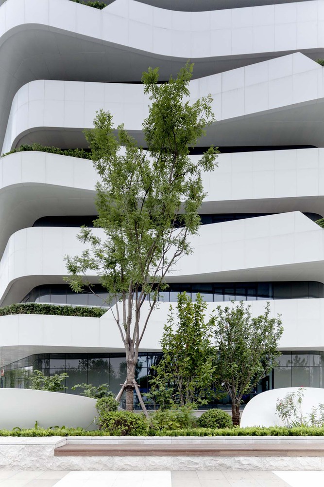 我们的设计采用模块化的概念,从研究办公的基本单元开始。每个办公单元的室内平面尺度是一个或者两个8.4米乘8.4米结构框架单位加上周边3.3米的悬挑,并配有一个功能核,其中有一部楼梯、一部电梯和一个卫生间。这样的大小单位组合在一起可以形成几个基本的形体:I形、T形、L型、以及十字形,以便组合成更丰富的建筑组团和室外空间。几个基本组合的功能核设计既需要解决办公单元之间的衔接,又需要使交通面积最精简,以得到最大化的有效办公空间。楼的高度可以是5层到7层。