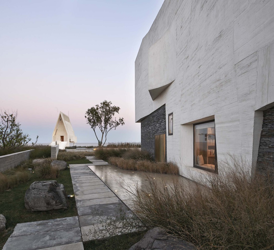 建筑的设计意图在于创造一系列动态空间,以提供多种小型聚会场所以及更多娱乐性公共空间。自入口漫步进入T宅,住户即可感受到由各方流淌而来的漫射光线与新鲜空气。建筑具有多处精心布置的大窗,为室内提供充足的光线,使照明的需求降至最低。底层整体为开放式空间,有半室外门廊、厨房、餐厅及图书馆,挑高的客厅拥抱海天景致,给人以开放透气之感。位于一楼的起居空间面向无需打理的外部花园,而花园介于私人聚会使用与邻居借过之间,灵活多变,同时也是通往海滩活动的最佳途径。图书馆则与之相反,天窗之下深嵌窗边的龛座坐拥私密小景,是独处时休闲阅读的最佳去处