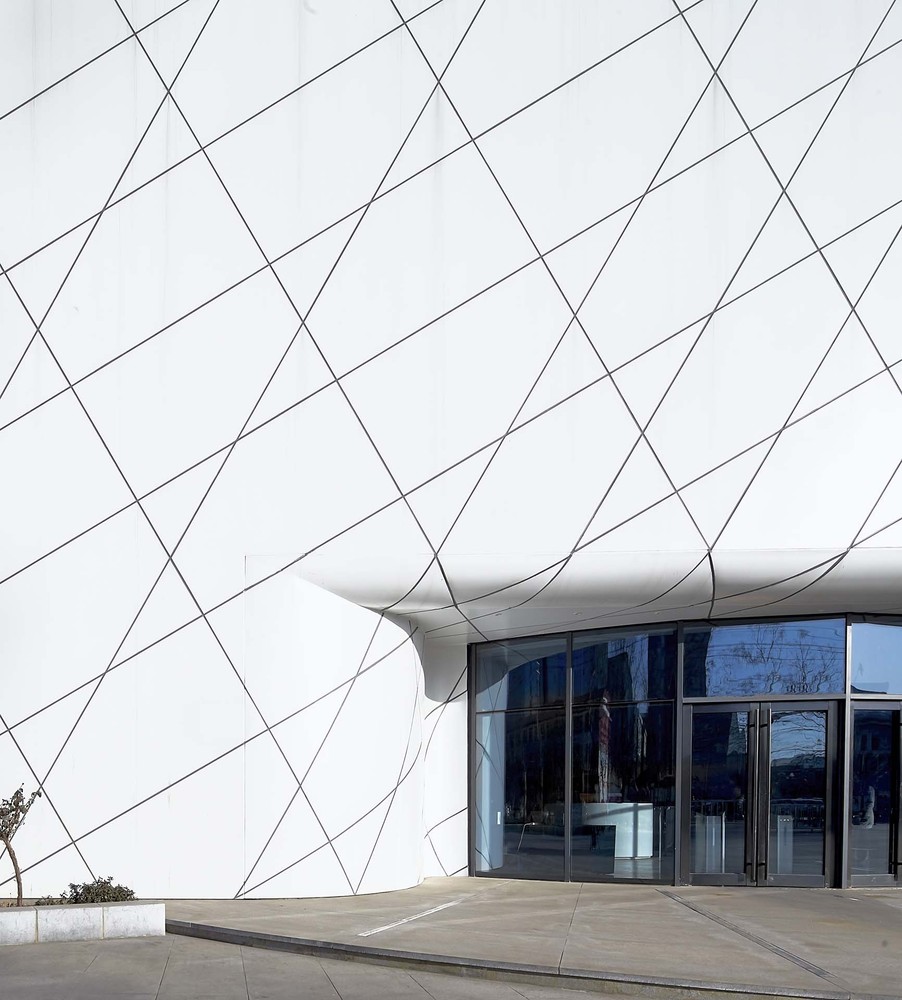 常规模式是沿着遗址坑周边安排参观流线。在这里,我们把主要参观流线悬吊在空中,提供了比常规模式高效且更为丰富的参观体验。一个巨大的环形坡道连接着入口层和参观层