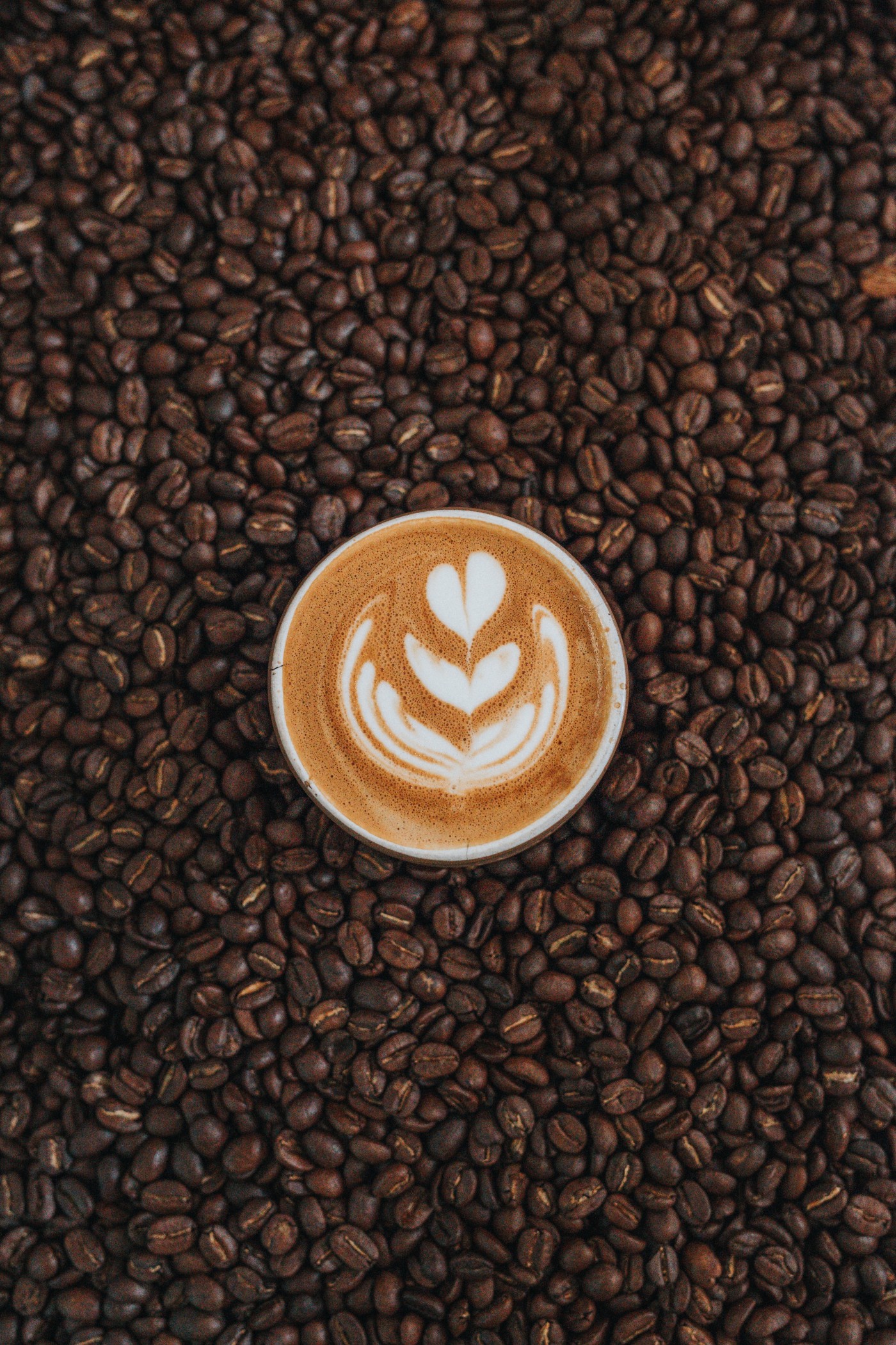 美味的拉花咖啡与咖啡豆图片