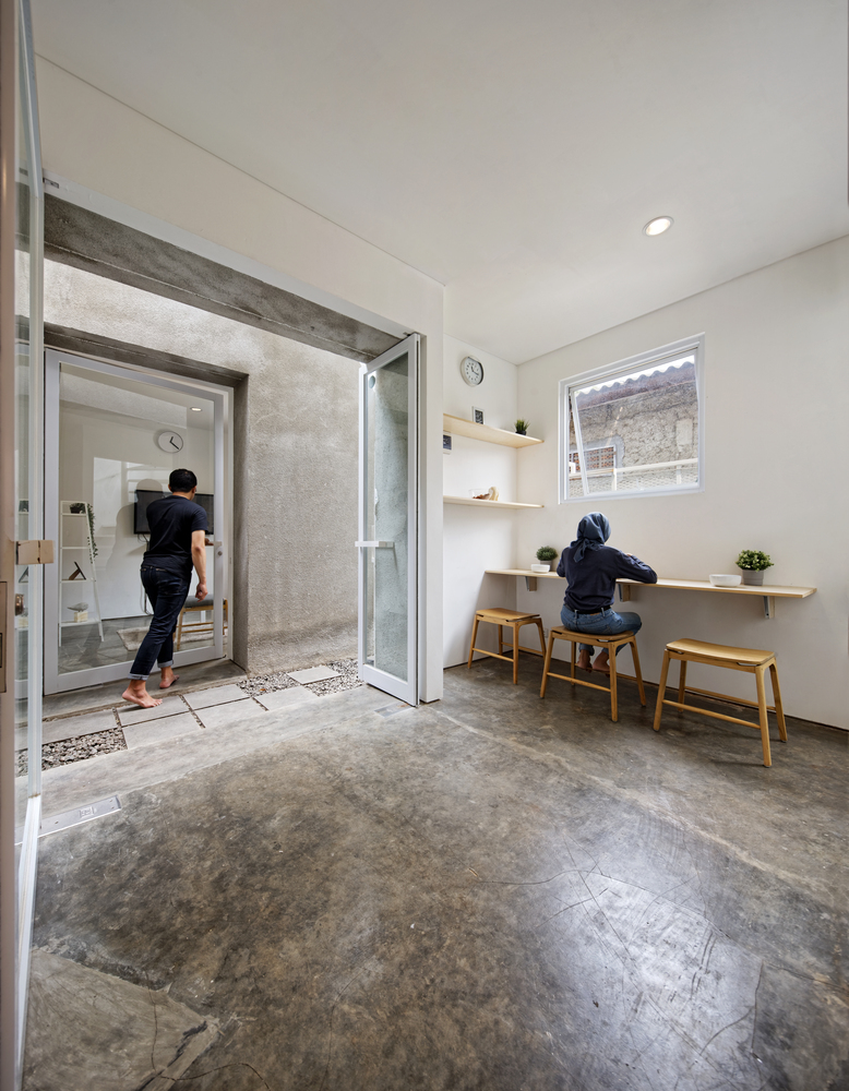 另一侧的住宅则配置了一个带卫生间的卧室和一个起居室。公共空间将这个狭小的用地组织起来,使底层场地能够被灵活流动地利用。双生宅之中,每一个家庭都有着各自的私密区域,但同时依旧能够互相交流。经由通过两栋建筑的入口的相对关系,公共空间被联为了一体