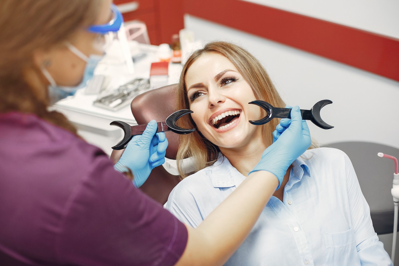 用镊子拔牙的过程，女性病人在牙科诊所手术期间的特写肖像照片摄影图片_ID:310878521-Veer图库