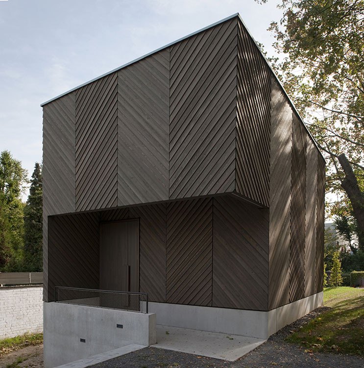 钟楼标志着从街上进入场地的入口。游客可以通过一个简单的长方形入口进入教堂,在此首先会经过一个低矮的门厅,门厅两个低矮的侧翼向中殿开放,通过这一小型的现代教区,在某种程度上重新诠释了巴西利卡的经典建筑。侧翼容纳了圣器室,社区活动室,音乐教室和厨房。中殿提供了开阔的空间,里面可活动的椅子可以根据社区活动重新安排摆放,而门厅上方的讲坛提供了额外的座位。在祭坛后面,彩色的木制屏风一直延伸向屋顶,暗示着位于其后的风琴。阳光从上方进入教堂,照射着祭坛的墙,从讲坛的后上方带来光亮,在一块亚光玻璃屏幕上照出叶子的影子。在夜晚,悬挂在低处的灯营造出一个有温暖光线的氛围,创造了亲切的尺度。