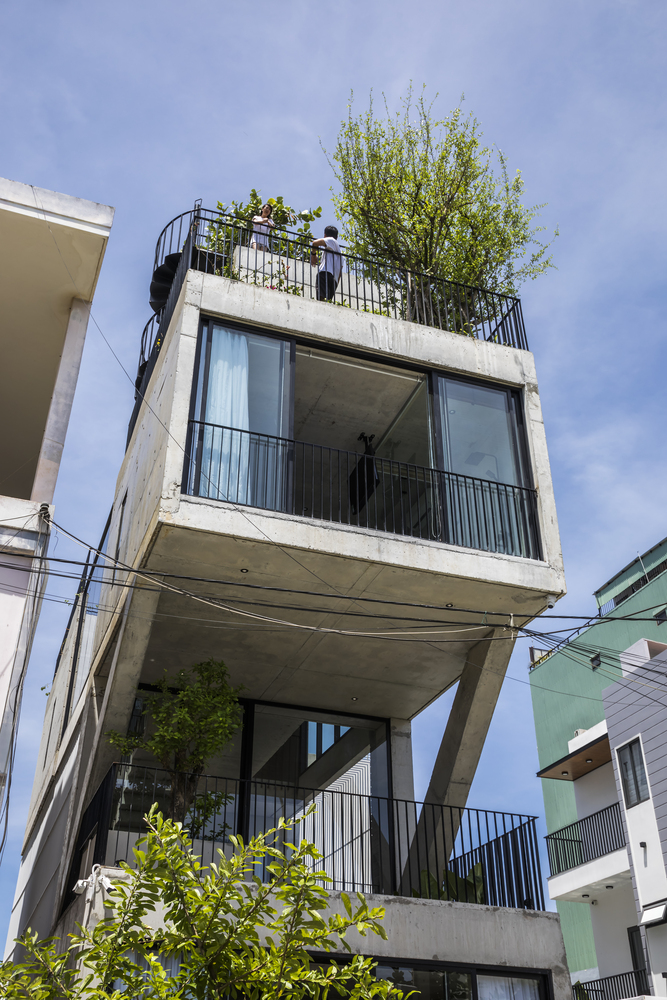 空间:简易混凝土“盒子”的组合在房屋内部创造了一个灵活通风的空间,切出的大型中庭可以将绿植带入室内。较少的墙壁和较大的体块促进自然光和风的流通。所有空间都通过走廊桥和楼梯相连,形成的中庭也鼓励家人进行视觉和言语上交流。