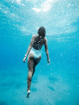 蓝色海域潜水的游泳女郎