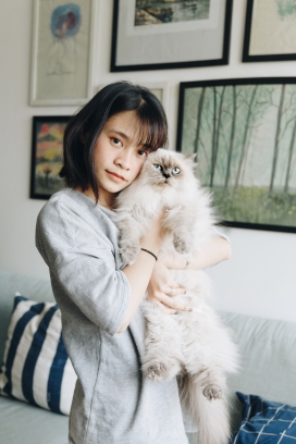 抱褴褛猫的亚洲姑娘