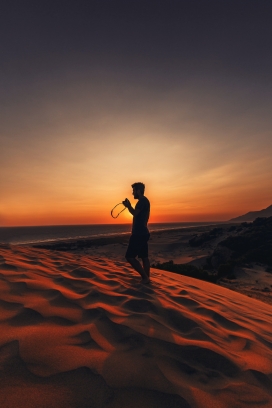 傍晚在沙漠中徒步的男性摄影师