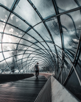 玻璃钢筋隧道下行走的男子