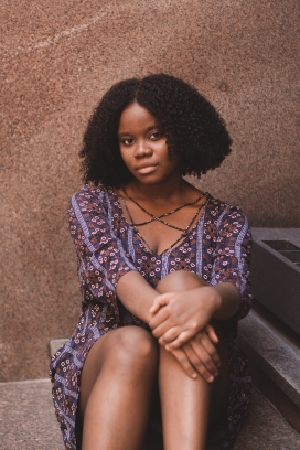 坐在地上的黑卷发爆炸头非洲女郎