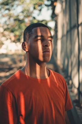 脸部被阳光亲吻的T恤短发男子