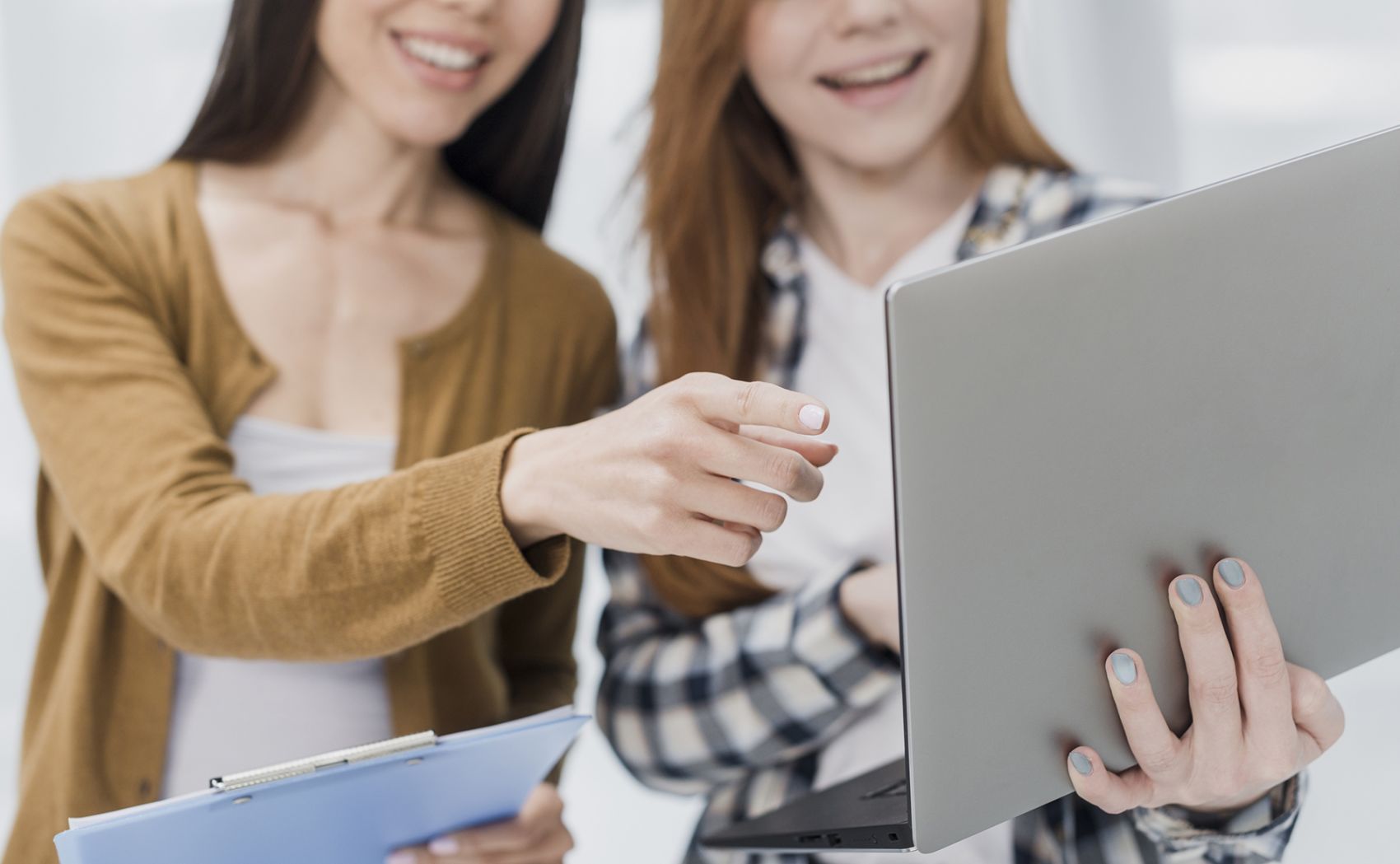 用笔记本电脑讨论的女性同事图片