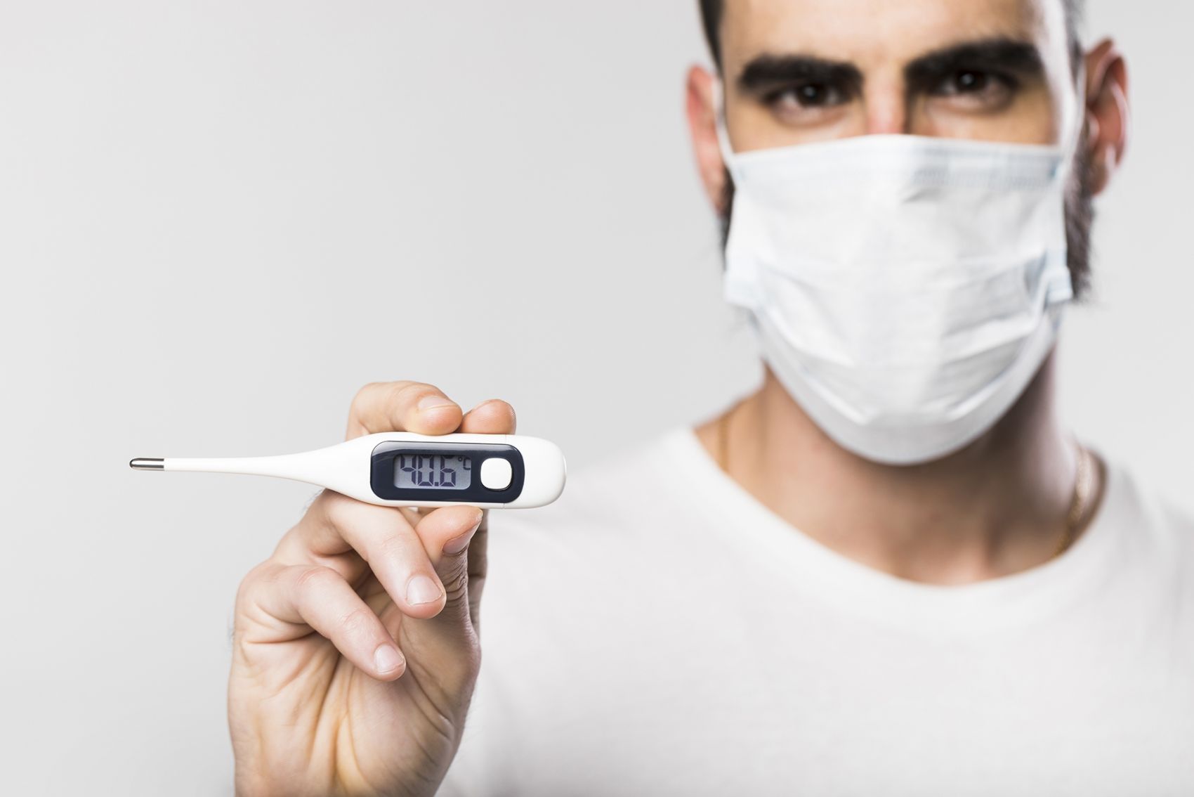 手拿体温计戴口罩的男子图片