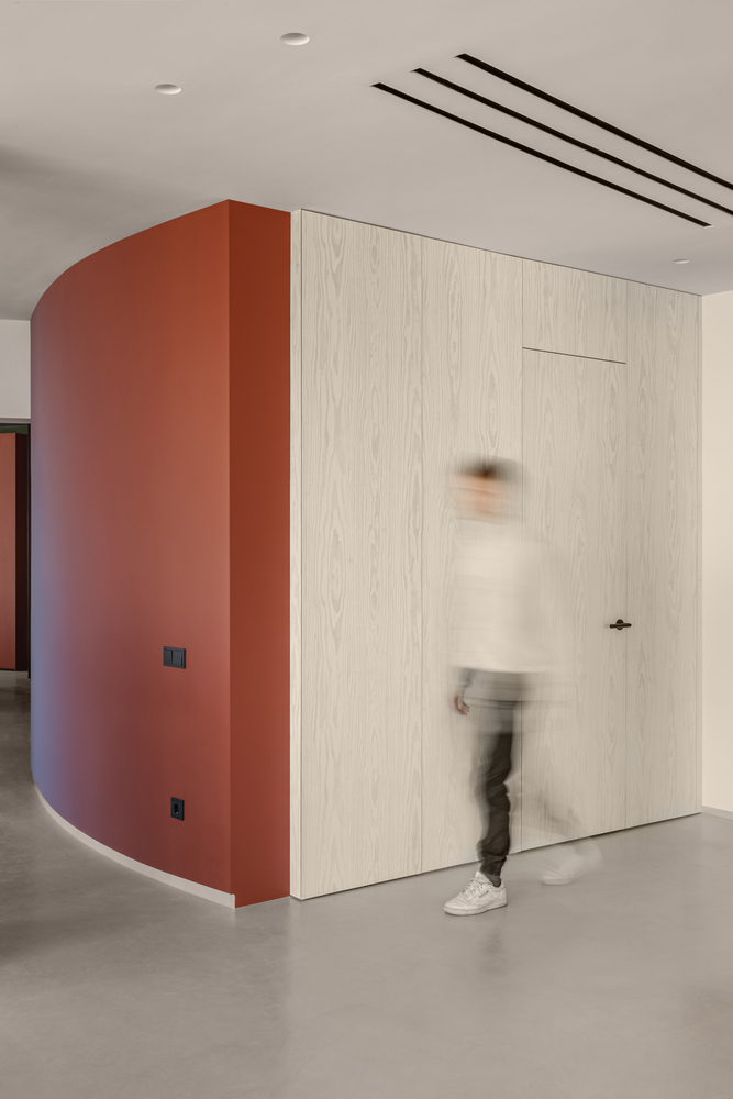 主卧也被安置在这么一堵隔墙的后面。我们以“极简”为原则,特意将所有非必需用品都藏起来,比如储物柜和电箱就被我们藏在公寓入口面板的后面。我们设置了许多这样的隐藏区域,让橱柜和其他非必需的家用品不会出现在主要空间里。我们还设置了额外的化妆间、洗衣房和一间客卧。甚至连电视机都被我们省去了,取而代之的是公寓内的投影仪。卧室和客厅的墙被用作屏幕,投射图片和视频。