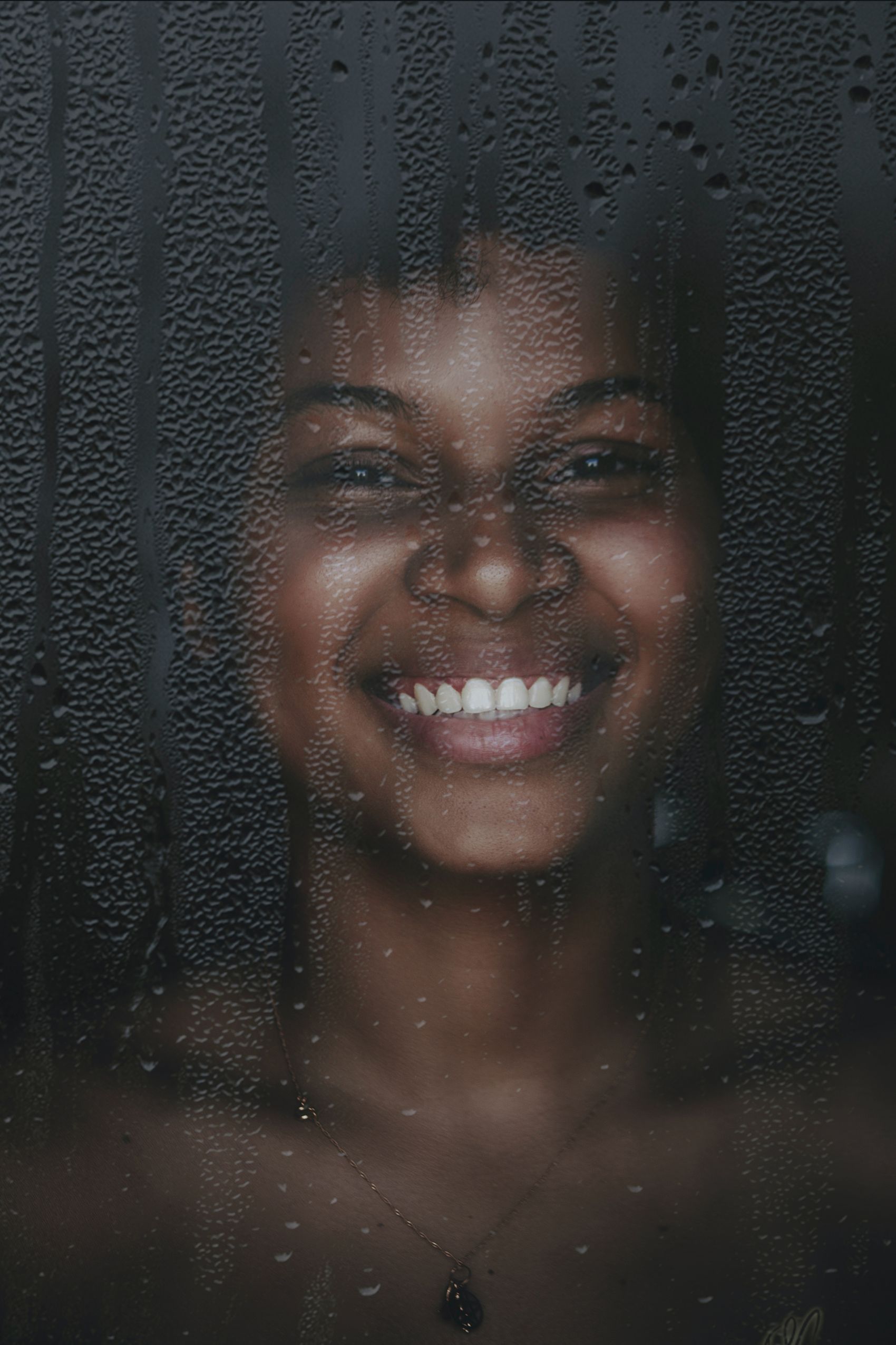 在带水珠玻璃钱露齿微笑的黑妹图片