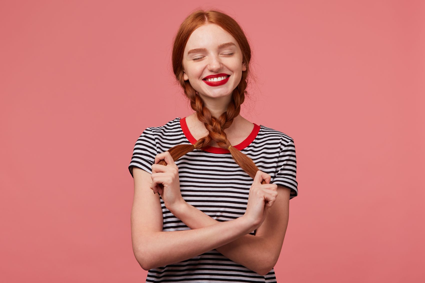 闭眼露齿抓辫子笑的长发美女图片