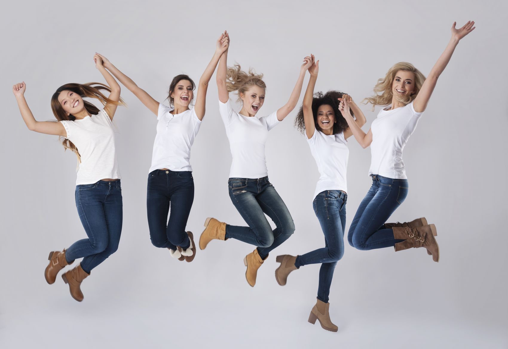 穿牛仔裤一起跳跃的金发美女姐妹图片