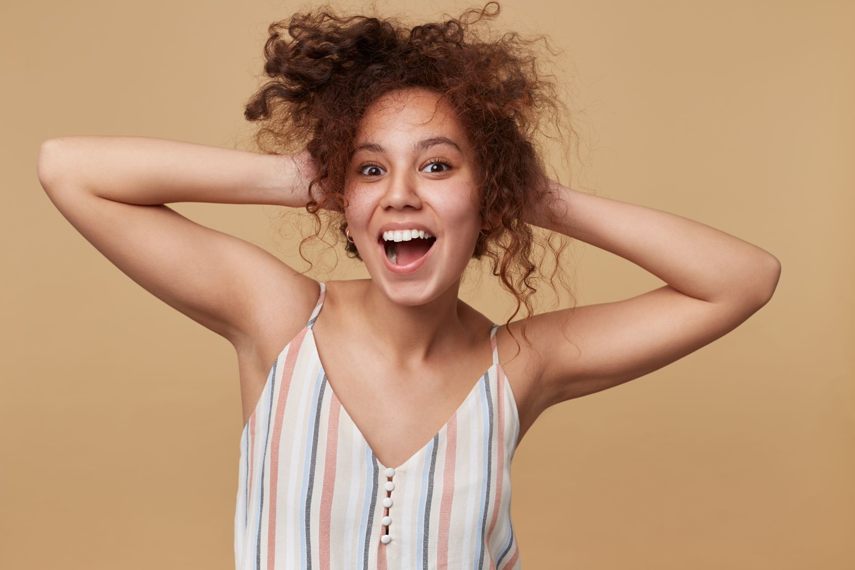 双手抱头开心笑的吊带裙女郎图片