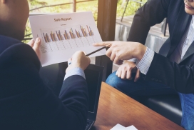 在咖啡店两位讨论图表的商务人士