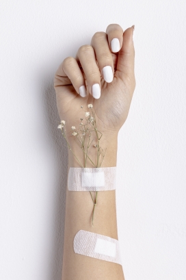 用白色创口贴绑植物的女子手