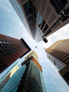 仰拍高楼群的飞机