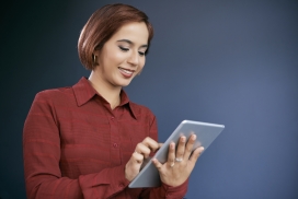 操作平板电脑的短发红衣女子