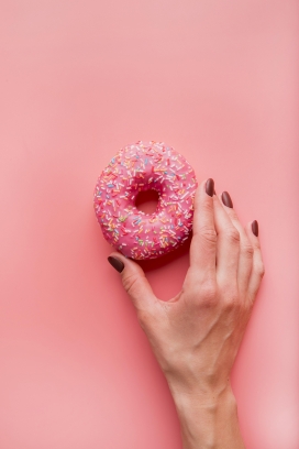 手拿红色马卡龙饼干的手