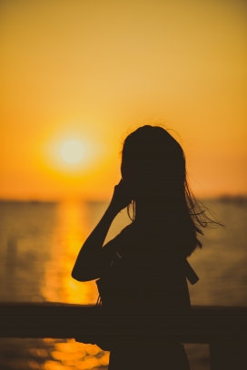 夕阳下湖边的美女剪影图