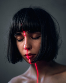 脸部被红色激光照射的短发美女