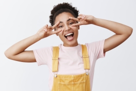 身穿吊带裙用手势比做眼镜的非洲短卷发美女