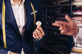 手拿纽扣的裁缝西装男