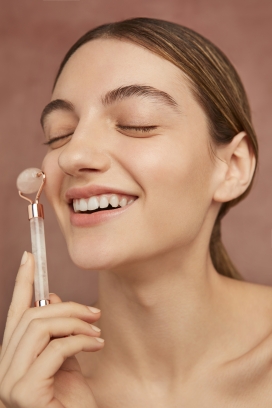 闭眼微笑给脸按摩的肌肤女郎