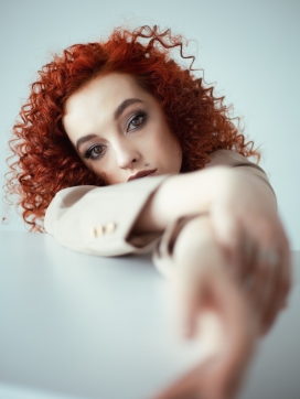 靠在桌上的卷发痣女郎