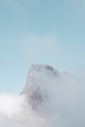 蓝色背景下被雾气包围的山顶