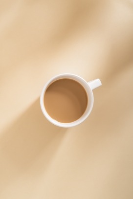 浅黄色桌上的咖啡杯