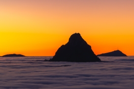 日落下被雾气环抱的山垛风景图