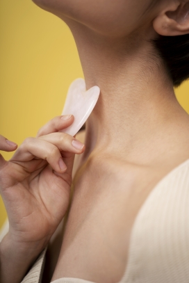 用塑料片刮痧脖子的女性图