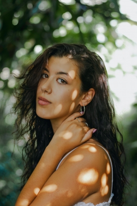 阳光摸脖子的卷发美女