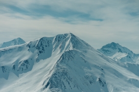 浅蓝色雪山山顶上的十字架