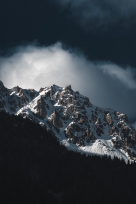 白色乌云下的雪山山峰