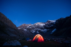 傍晚雪山脚下的露营帐篷夜景图