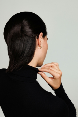 戴耳环摸黑色毛衣领的女性背部图