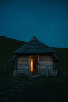 夜色下开着小灯的三角茅草屋
