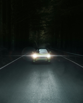 行驶在夜间马路行驶开着灯光的汽车