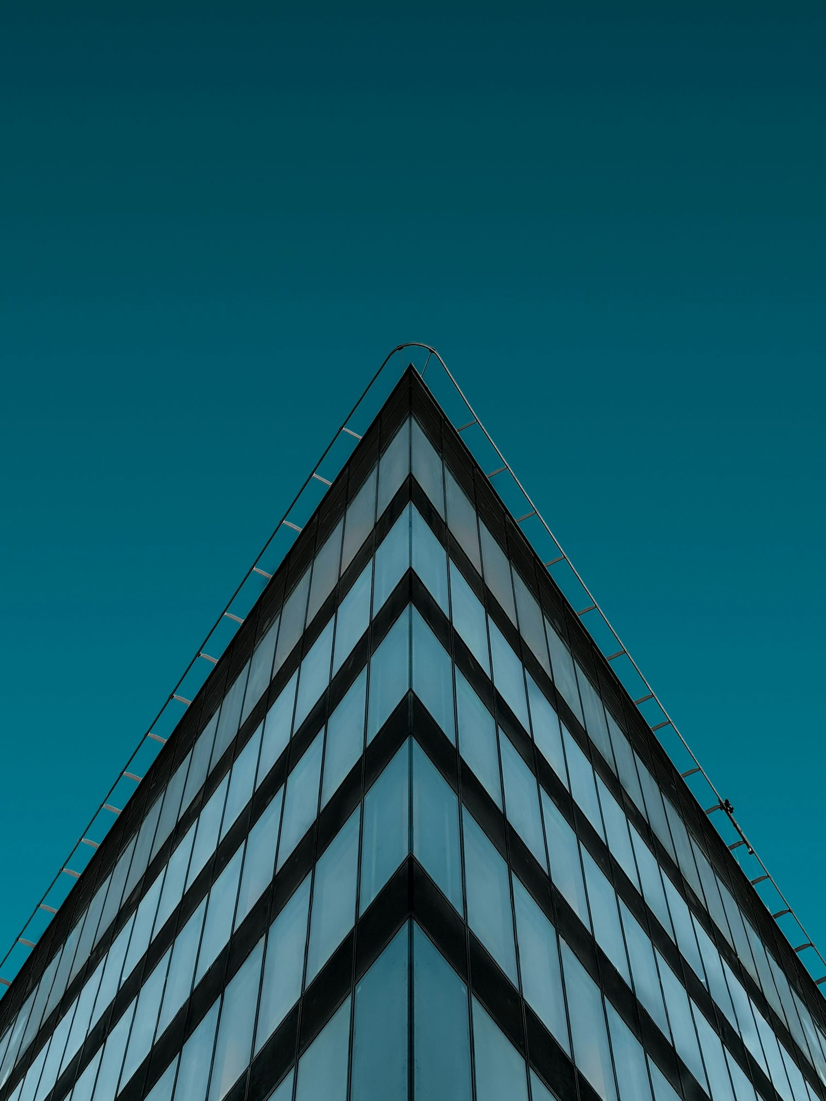 玻璃幕墙建筑锐角美学与深蓝天空的视觉碰撞图片