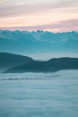 雾漫层峦夕照图景：粉紫天幕下的雪岭云谷自然风光