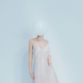 浅调极简人像创意：气球遮面与柔色氛围的先锋视觉作品