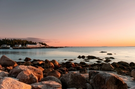 静谧海岸的橙粉暮色与礁石渔乡