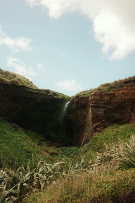 新西兰海岸悬崖瀑布 亚麻植被映衬澄澈蓝天